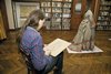 Studentka kreslí historické šaty v knihovně Severočeského muzea